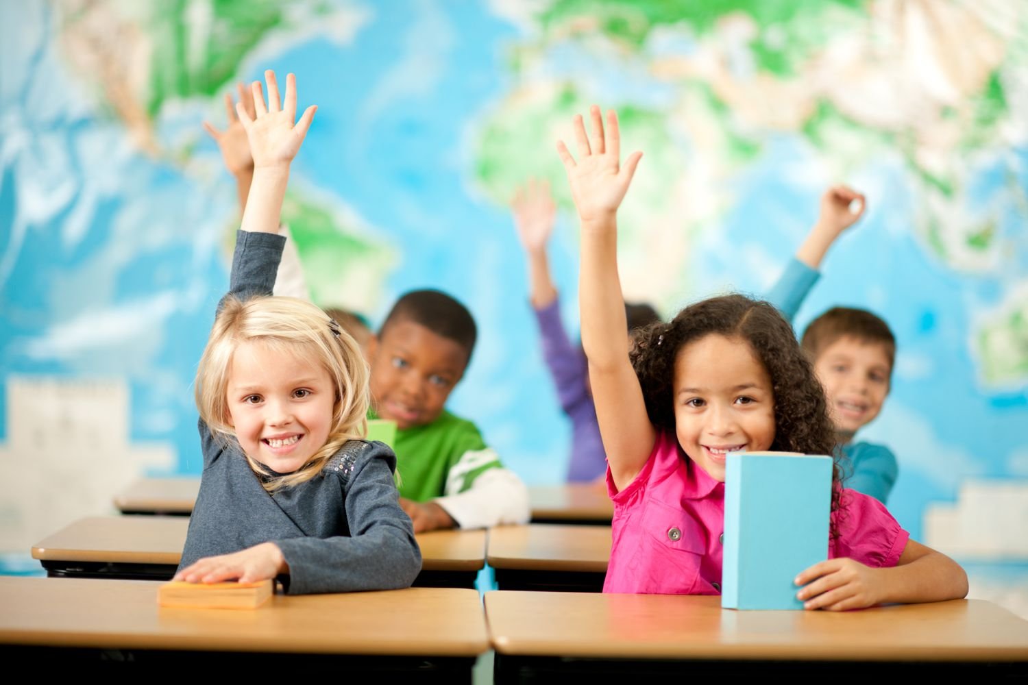 Getty first grade class students raising hands smiling LARGE Christopher Futcher 574b53845f9b5851654693f2